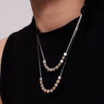 Two-tone gold and silver stainless steel jewelry set featuring alternating smooth silver beads, gold star motifs, textured gold station beads, and a sleek snake chain.