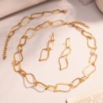 Stainless steel bold wavy geometric link chain necklace, chain bracelet, and drop earrings set image.