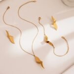 Stainless steel abstract twisted ribbon geometric pendant necklace, chain bracelet, and drop earrings set.