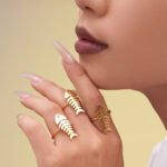 Stainless steel gold fishbone and heart jewelry set featuring long station sweater necklace, drop earrings, and fishbone statement ring.