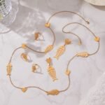 Stainless steel gold fishbone and heart jewelry set featuring long station sweater necklace, drop earrings, and fishbone statement ring.