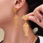 Stainless steel gold fishbone and heart jewelry set featuring long station sweater necklace, drop earrings, and fishbone statement ring.