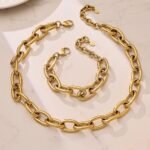 Bold oversized oval cable link chain necklace and matching bracelet jewelry set in 18K gold plated and polished silver stainless steel finishes.