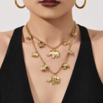 18K gold plated stainless steel elephant charm necklace and bracelet set featuring a prominent central elephant pendant and smaller charm accents on a beaded ball chain.