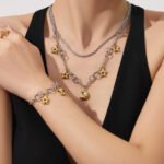 Stainless steel celestial star and cubic zirconia crescent moon charm necklace and matching charm bracelet set in gold and two-tone finishes.