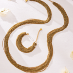 Draped multi-strand liquid chain long necklace and wide cuff bracelet jewelry set in gold, silver, and two-tone stainless steel finishes.