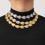 Textured ribbed seashell motif link necklace and bracelet set in two-tone gold and silver stainless steel finishes.
