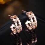Rose gold cutout hoop earrings featuring scalloped edges, hexagonal cutout pattern, AAA cubic zirconia accents, and 925 sterling silver posts.