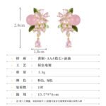 Ornate botanical dangle earrings featuring dual crystal flower blooms, glossy green enamel leaves, a smooth round bead, and a dangling teardrop CZ in silver and gold metal finishes.