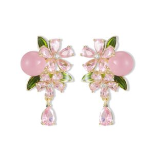 Ornate botanical dangle earrings featuring dual crystal flower blooms, glossy green enamel leaves, a smooth round bead, and a dangling teardrop CZ in silver and gold metal finishes.