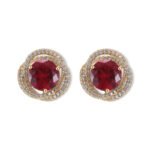 Round ruby stud earrings wholesale featuring a vibrant red central CZ stone wrapped in a swirling pavé cubic zirconia halo with S925 sterling silver posts from junejewelry.com