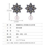 Snowflake CZ freshwater pearl drop earrings featuring an intricate starburst starburst pattern, princess-cut gems, micro-paved borders, and a round freshwater pearl dangle