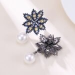 Snowflake CZ freshwater pearl drop earrings featuring an intricate starburst starburst pattern, princess-cut gems, micro-paved borders, and a round freshwater pearl dangle