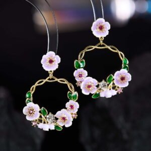 Twisted round hoop earrings adorned with hand-painted enamel flowers, green leaves, and CZ crystal accents in purple and white options.