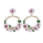 Twisted round hoop earrings adorned with hand-painted enamel flowers, green leaves, and CZ crystal accents in purple and white options.