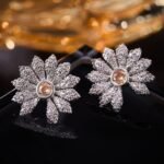 Micro pave CZ flower stud earrings featuring radiating textured petals encrusted with cubic zirconia, a amber crystal center, and 925 sterling silver posts