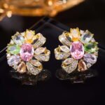 Floral pinwheel CZ cluster stud earrings featuring a swirling halo of multi-cut gemstones, micro-paved ribbon swirls, and 925 sterling silver ear posts