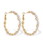 Cubic zirconia oval hoop earrings featuring continuous prong-set round stones, available in gold and silver tones in two sizes.