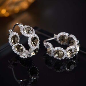 Oval halo CZ hoop earrings featuring faceted oval crystal main stones surrounded by micro-pavé halos on a thick hoop frame with 925 sterling silver posts.