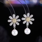 Daisy CZ pearl drop earrings featuring a full pavé crystal flower stud with a yellow CZ pistil center, high-lustre pearl drop, and 925 sterling silver ear posts.