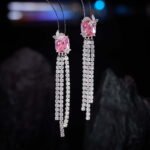 Long tassel CZ drop earrings featuring a cushion-cut colored crystal stud with marquee crystal butterfly accents and cascading cubic zirconia fringe strands on palladium-plated brass with 925 sterling silver posts.