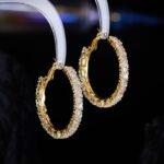 Round hoop earrings set with continuous sparkling clear cubic zirconia crystals, available in gold and silver finishes.