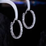 Round hoop earrings set with continuous sparkling clear cubic zirconia crystals, available in gold and silver finishes.