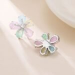 Five-petal flower stud earrings crafted with pear-cut crackle glass stones, featuring a pavé crystal starfish centerpiece in pink, green, and pastel rainbow colorways.
