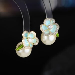 Enamel flower pearl stud earrings featuring micro-paved CZ petal borders, center round stone, glossy pearl drop, and 925 sterling silver ear posts