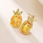 Sparkling pineapple stud earrings featuring marquise-cut crystal crown leaves, lattice fruit body, and micro-pavé accents in yellow, pink, and clear options.