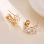 Mother of pearl flower hoop earrings featuring carved shell flower petals, sparkling AAA cubic zirconia accents, 18K gold-plated C-shape hoop base, and 925 sterling silver ear posts.