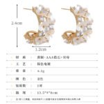 Mother of pearl flower hoop earrings featuring carved shell flower petals, sparkling AAA cubic zirconia accents, 18K gold-plated C-shape hoop base, and 925 sterling silver ear posts.