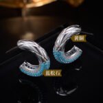 Chunky quilted diamond-pattern C-shaped half hoop earrings with a micro-set turquoise bead trim on the bottom edge, available in gold and silver metal finishes.
