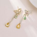 Butterfly CZ long dangle earrings featuring a micro-paved crystal butterfly top, asymmetric teardrop gemstone drops, and 925 sterling silver ear posts.