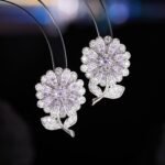 Sparkling CZ sunflower stud earrings wholesale featuring pave-set cubic zirconia flower petals, leafed stems, and 925 sterling silver posts available on junejewelry.com