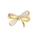 Delicate bow knot shell brooch wholesale featuring pavé cubic zirconia ribbons, inlaid natural mother of pearl shell loops, and a gold-plated finish from junejewelry.com
