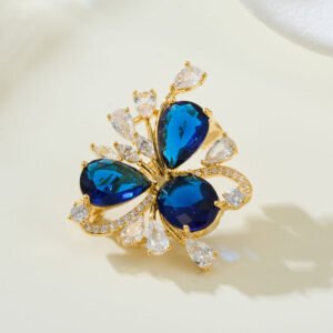 Crystal flower brooch wholesale featuring three prominent teardrop CZ petals surrounded by pavé ribbons and marquise crystal accents in gold plating from junejewelry.com