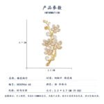 Delicate plum blossom pearl brooch wholesale featuring enamel floral petals, cz crystal pistils, and pearl accents on a gold-plated branch from junejewelry.com
