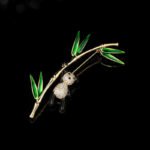 Playful Chinese style panda bamboo CZ brooch wholesale featuring a micro-pave cubic zirconia panda climbing a gold-plated bamboo stalk with vibrant green enamel leaves from junejewelry.com