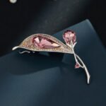 Crystal flower brooch wholesale featuring faceted teardrop glass petals bordered by multi-colored paved rhinestones on an elegant stem in silver plating from junejewelry.com