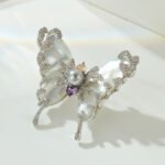 Pearl shell butterfly brooch wholesale featuring natural mother-of-pearl wings overlaid with pavé CZ vine tendrils, a center faux pearl, and multi-color cubic zirconia accents from junejewelry.com