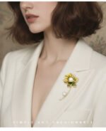 Oriental luxury Chinese style enamel lotus pearl brooch wholesale featuring translucent enamel petals, yellow enamel stamens, micro-pave CZ outlines, and dual freshwater pearls on a gold stem from junejewelry.com