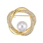 Geometric round pearl brooch wholesale featuring interlocking polished metal and micro-pavé cubic zirconia swirl rings framing a round center pearl from junejewelry.com