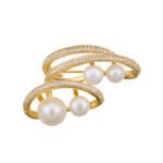 Light luxury layered pearl cluster brooch wholesale featuring multi-tiered micro-pave cubic zirconia curved bands nestled with lustrous white pearls from junejewelry.com