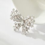 Pearl butterfly brooch wholesale featuring delicate pavé cubic zirconia wings, pearl-tipped accents, and a silver-plated finish from junejewelry.com