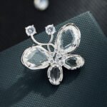 Crystal butterfly brooch wholesale featuring faceted glass crystal wings, cubic zirconia center body, and round CZ antenna tips from junejewelry.com