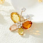 Crystal butterfly brooch wholesale featuring faceted glass crystal wings, cubic zirconia center body, and round CZ antenna tips from junejewelry.com