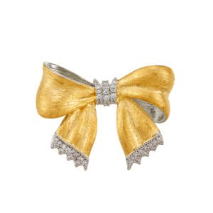 Elegant brushed bow knot brooch wholesale featuring brushed matte gold metal ribbons, pavé cubic zirconia center knot and fringe trim from junejewelry.com