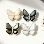 Elegant magnetic mother of pearl butterfly brooch wholesale featuring natural white or black shell wings, micro-pave cubic zirconia body, and a fabric-safe pinless magnetic back clasp from junejewelry.com