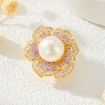 High-end magnetic camellia CZ pearl brooch wholesale featuring micro-pave white and purple cubic zirconia petals, a luminous glass pearl center, and a strong pinless magnetic back clasp in gold or rhodium finish from junejewelry.com